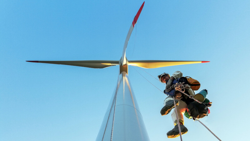 Dropped object prevention and tethering tools in use as a worker secures a safety harness clip to a D-ring while working at height